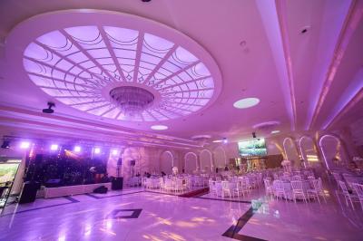Vue aérienne d'une table élégante décorée de fleurs blanches avec des chaises dorées et un sol en marbre clair.