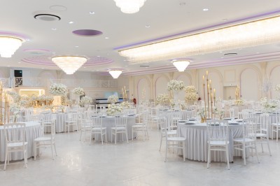 Vue aérienne d'une table élégante décorée de fleurs blanches avec des chaises dorées et un sol en marbre clair.