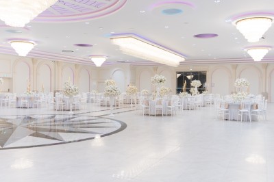 Vue aérienne d'une table élégante décorée de fleurs blanches avec des chaises dorées et un sol en marbre clair.