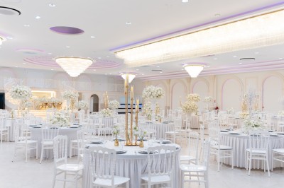 Vue aérienne d'une table élégante décorée de fleurs blanches avec des chaises dorées et un sol en marbre clair.