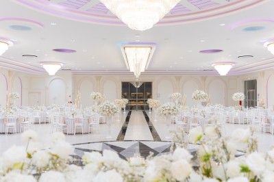 Vue aérienne d'une table élégante décorée de fleurs blanches avec des chaises dorées et un sol en marbre clair.