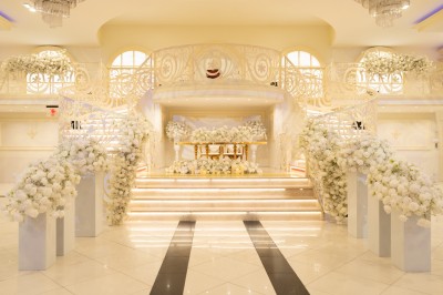 Miniature Location salle Saint-Germain-Laval (Seine-et-Marne) - Palais 77 #3 Salle de réception élégante avec tables décorées de nappes blanches, centres de table floraux et éclairage rose.