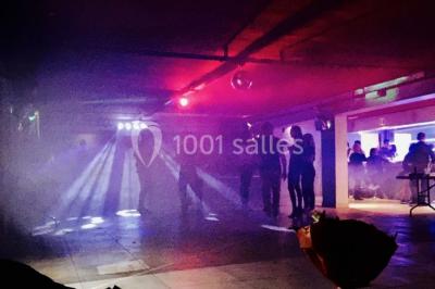 Globes décoratifs, confettis colorés et petites boîtes blanches ornées de rubans violets disposés sur une table festive.