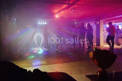 Globes décoratifs, confettis colorés et petites boîtes blanches ornées de rubans violets disposés sur une table festive.