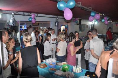 Globes décoratifs, confettis colorés et petites boîtes blanches ornées de rubans violets disposés sur une table festive.