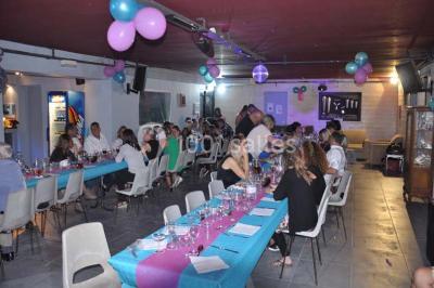 Globes décoratifs, confettis colorés et petites boîtes blanches ornées de rubans violets disposés sur une table festive.