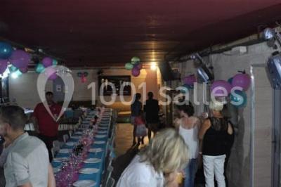 Globes décoratifs, confettis colorés et petites boîtes blanches ornées de rubans violets disposés sur une table festive.