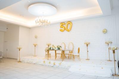 Lettrage décoratif noir entouré de fleurs rouges, roses et feuillages verts sur fond blanc.