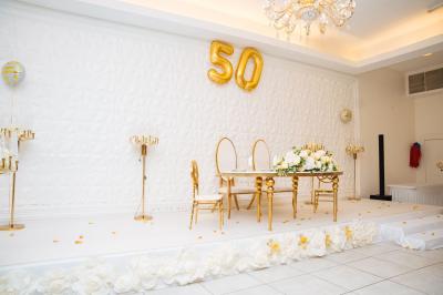 Lettrage décoratif noir entouré de fleurs rouges, roses et feuillages verts sur fond blanc.