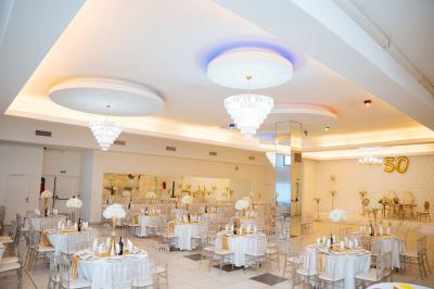 Lettrage décoratif noir entouré de fleurs rouges, roses et feuillages verts sur fond blanc.