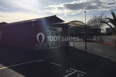 Table en inox avec étagère inférieure dans une cuisine professionnelle équipée de fours et d'équipements.