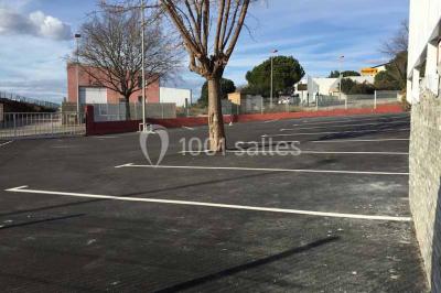 Table en inox avec étagère inférieure dans une cuisine professionnelle équipée de fours et d'équipements.