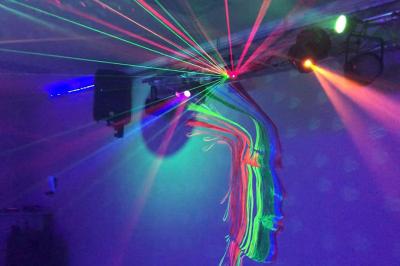 Table en inox avec étagère inférieure dans une cuisine professionnelle équipée de fours et d'équipements.