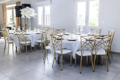 Table en inox avec étagère inférieure dans une cuisine professionnelle équipée de fours et d'équipements.