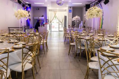 Table en inox avec étagère inférieure dans une cuisine professionnelle équipée de fours et d'équipements.
