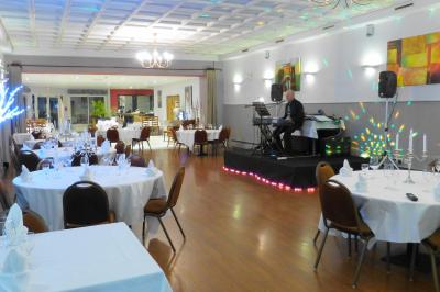 Parking extérieur vide avec un seul véhicule blanc, entouré de végétation et d'un mur en pierre.