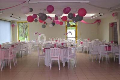 Salle lumineuse avec une table en métal, des fenêtres et une porte jaune donnant sur l'extérieur.