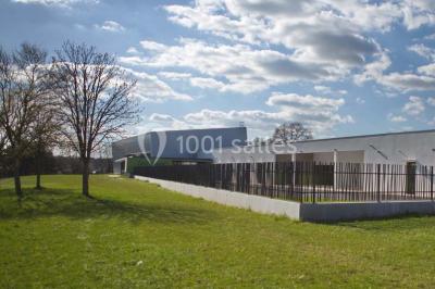 Cuisine professionnelle équipée avec plans de travail en inox, casseroles, assiettes empilées et appareils de cuisson.