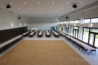 Cuisine professionnelle équipée avec plans de travail en inox, casseroles, assiettes empilées et appareils de cuisson.