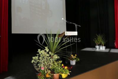 Cuisine professionnelle équipée avec plans de travail en inox, casseroles, assiettes empilées et appareils de cuisson.