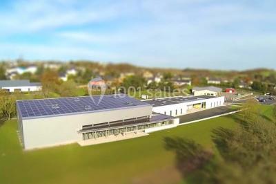 Cuisine professionnelle avec plans de travail en inox, casseroles, assiettes empilées et équipements de restauration.