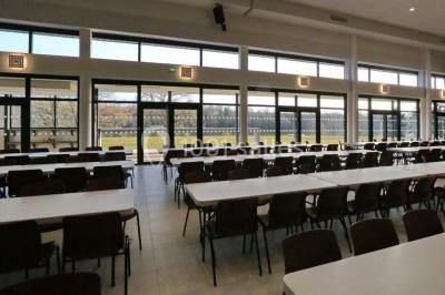 Cuisine professionnelle avec plans de travail en inox, casseroles, assiettes empilées et équipements de restauration.