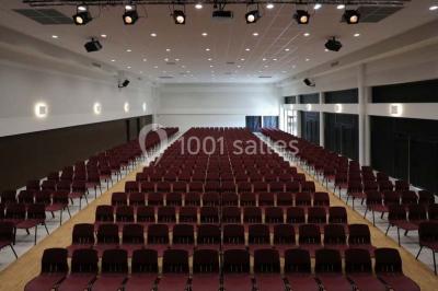 Cuisine professionnelle avec plans de travail en inox, casseroles, assiettes empilées et équipements de restauration.