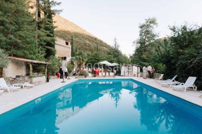 Des personnes discutent autour d'une table en tonneau, partageant des viennoiseries dans un cadre extérieur verdoyant.