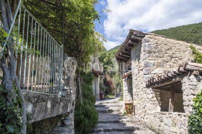 Des personnes discutent autour d'une table en tonneau, partageant des viennoiseries dans un cadre extérieur verdoyant.