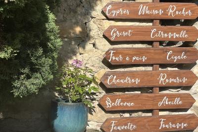 Des personnes discutent autour d'une table en tonneau, partageant des viennoiseries dans un cadre extérieur verdoyant.