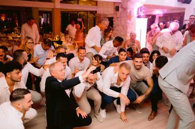 Des personnes discutent autour d'une table en tonneau, partageant des viennoiseries dans un cadre extérieur verdoyant.