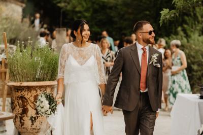 Des personnes discutent autour d'une table en tonneau, partageant des viennoiseries dans un cadre extérieur verdoyant.