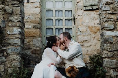 Des personnes discutent autour d'une table en tonneau, partageant des viennoiseries dans un cadre extérieur verdoyant.