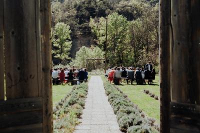 Des personnes discutent autour d'une table en tonneau, partageant des viennoiseries dans un cadre extérieur verdoyant.