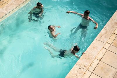 Des personnes discutent autour d'une table en tonneau, partageant des viennoiseries dans un cadre extérieur verdoyant.