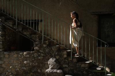 Des personnes discutent autour d'une table en tonneau, partageant des viennoiseries dans un cadre extérieur verdoyant.