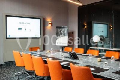 Bornes de recharge électriques Tesla alignées sur un parking, entourées de végétation et de voitures en arrière-plan.