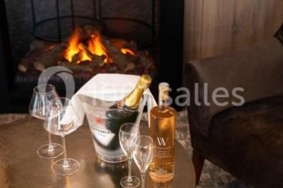 Bornes de recharge électriques Tesla alignées sur un parking, entourées de végétation et de voitures en arrière-plan.