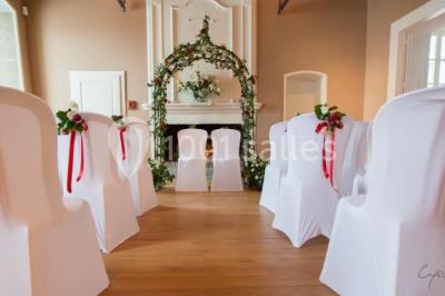 Un grand groupe de personnes en t-shirts verts pose joyeusement devant des véhicules stationnés en extérieur.