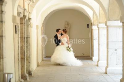 Un grand groupe de personnes en t-shirts verts pose joyeusement devant des véhicules stationnés en extérieur.