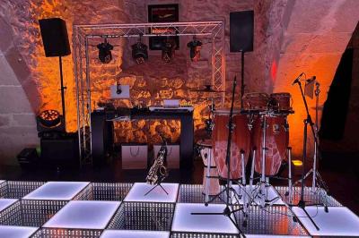 Un grand groupe de personnes en t-shirts verts pose joyeusement devant des véhicules stationnés en extérieur.