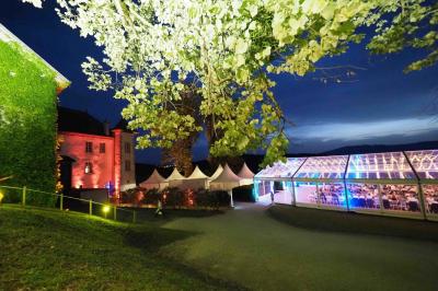 Un grand groupe de personnes en t-shirts verts pose joyeusement devant des véhicules stationnés en extérieur.
