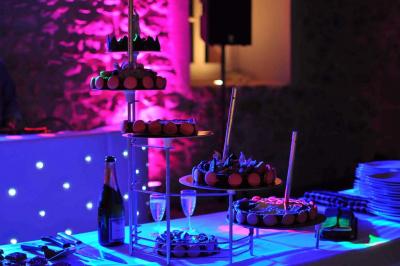 Un grand groupe de personnes en t-shirts verts pose joyeusement devant des véhicules stationnés en extérieur.