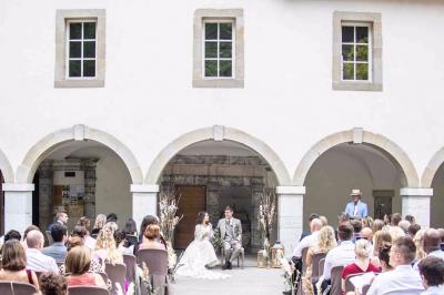 Un grand groupe de personnes en t-shirts verts pose joyeusement devant des véhicules stationnés en extérieur.