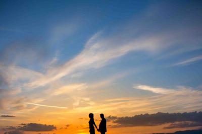 Un grand groupe de personnes en t-shirts verts pose joyeusement devant des véhicules stationnés en extérieur.