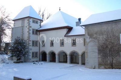 Un grand groupe de personnes en t-shirts verts pose joyeusement devant des véhicules stationnés en extérieur.