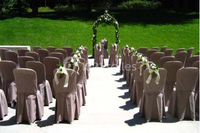 Un grand groupe de personnes en t-shirts verts pose joyeusement devant des véhicules stationnés en extérieur.