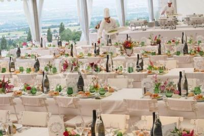 Un grand groupe de personnes en t-shirts verts pose joyeusement devant des véhicules stationnés en extérieur.