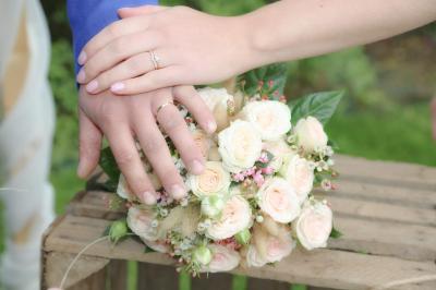 Table ronde élégamment dressée avec vaisselle, couverts, serviettes roses et centre de table floral coloré.
