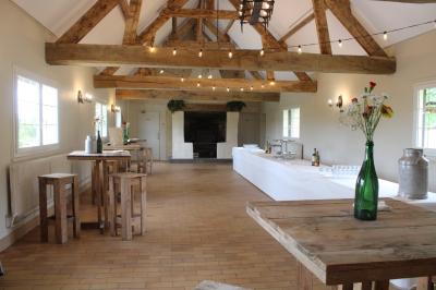 Table ronde élégamment dressée avec vaisselle, couverts, serviettes roses et centre de table floral coloré.